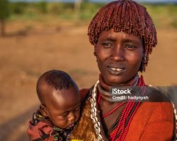 Woman from Hamer tribe holding her baby, Ethiopia, Africa. The Hamer tribe is an indigenous group of people in Africa, and this tribe lives in the southwestern region of the Omo Valley near Kenya, Africa. They are largely pastoralists.